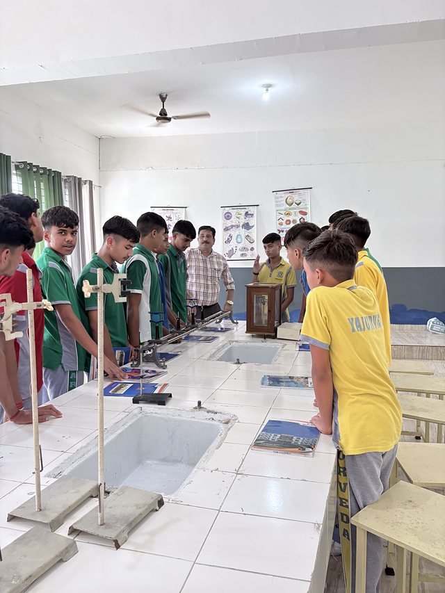 Students working at laboratory benches fitted with stands and sinks