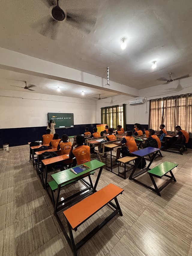 Wide view down a full classroom during a lesson